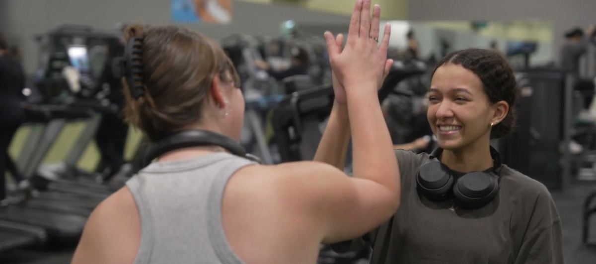 Members high-fiving on the gym floor